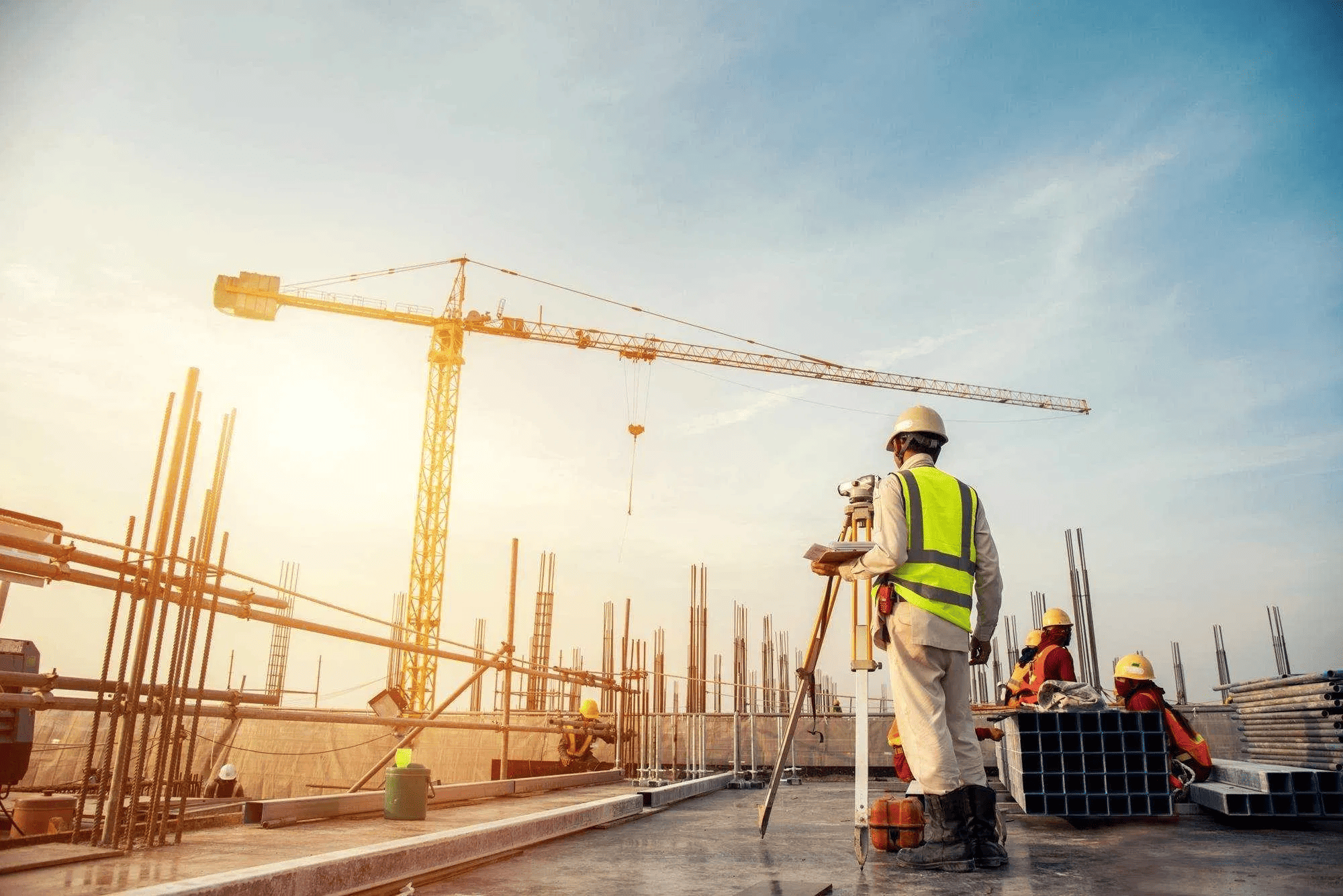 Engenheiro civil supervisionando obra com guindaste ao fundo, destacando a segurança na construção civil