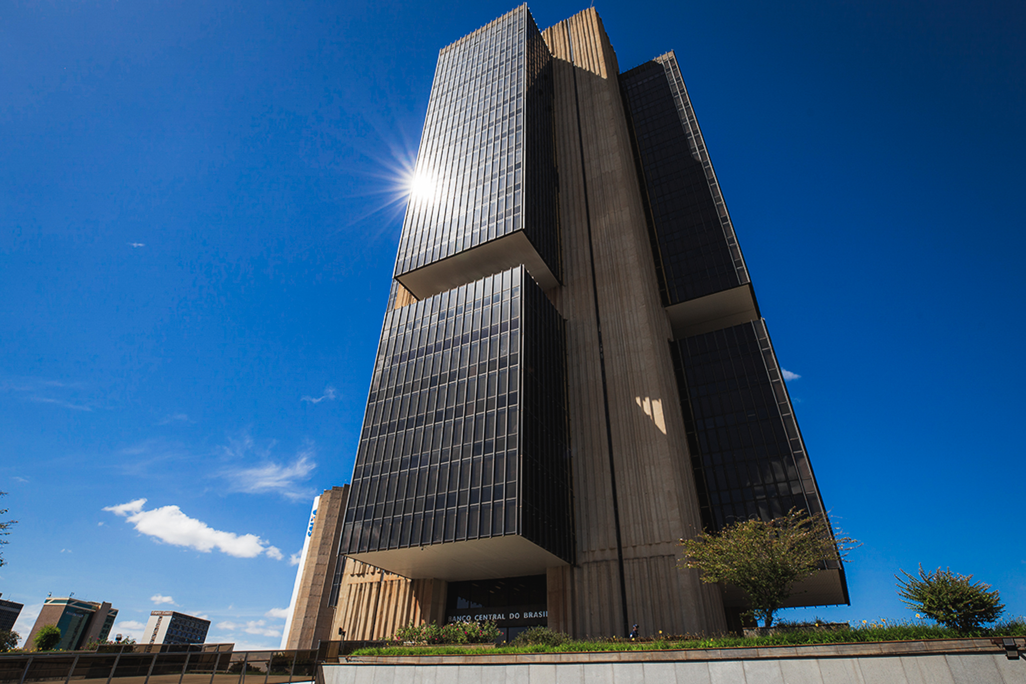 Fachada do edifício do Banco Central do Brasil em Brasília, com céu azul ao fundo e destaque para a arquitetura moderna da construção.