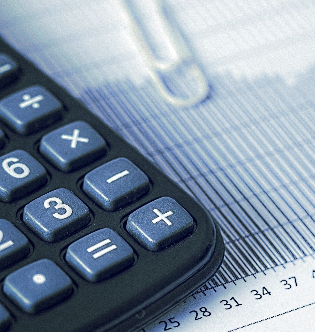 Calculadora e gráficos financeiros representando o impacto da alta da Selic e do IOF no mercado de seguros brasileiro em 2025