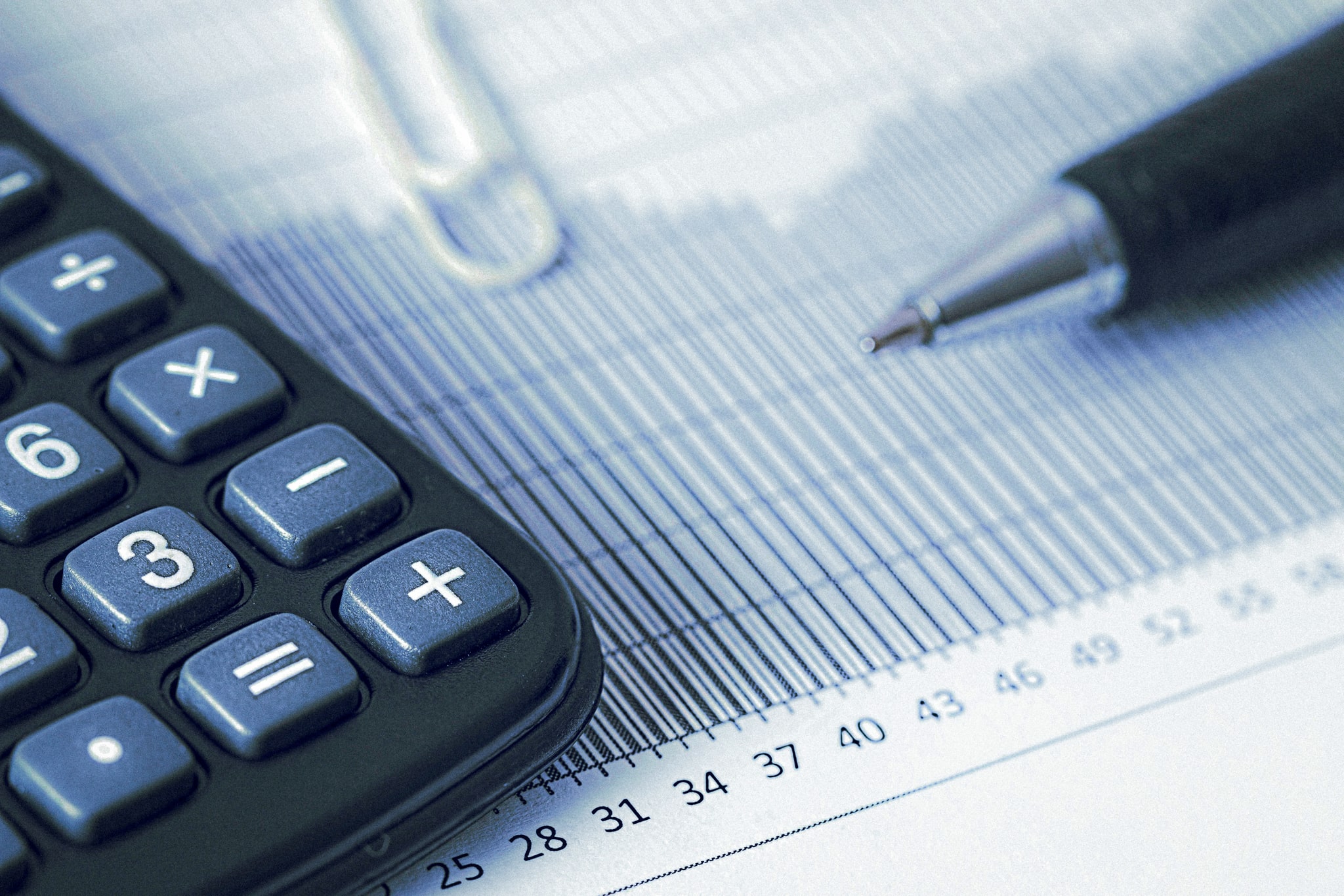 Calculadora e gráficos financeiros representando o impacto da alta da Selic e do IOF no mercado de seguros brasileiro em 2025