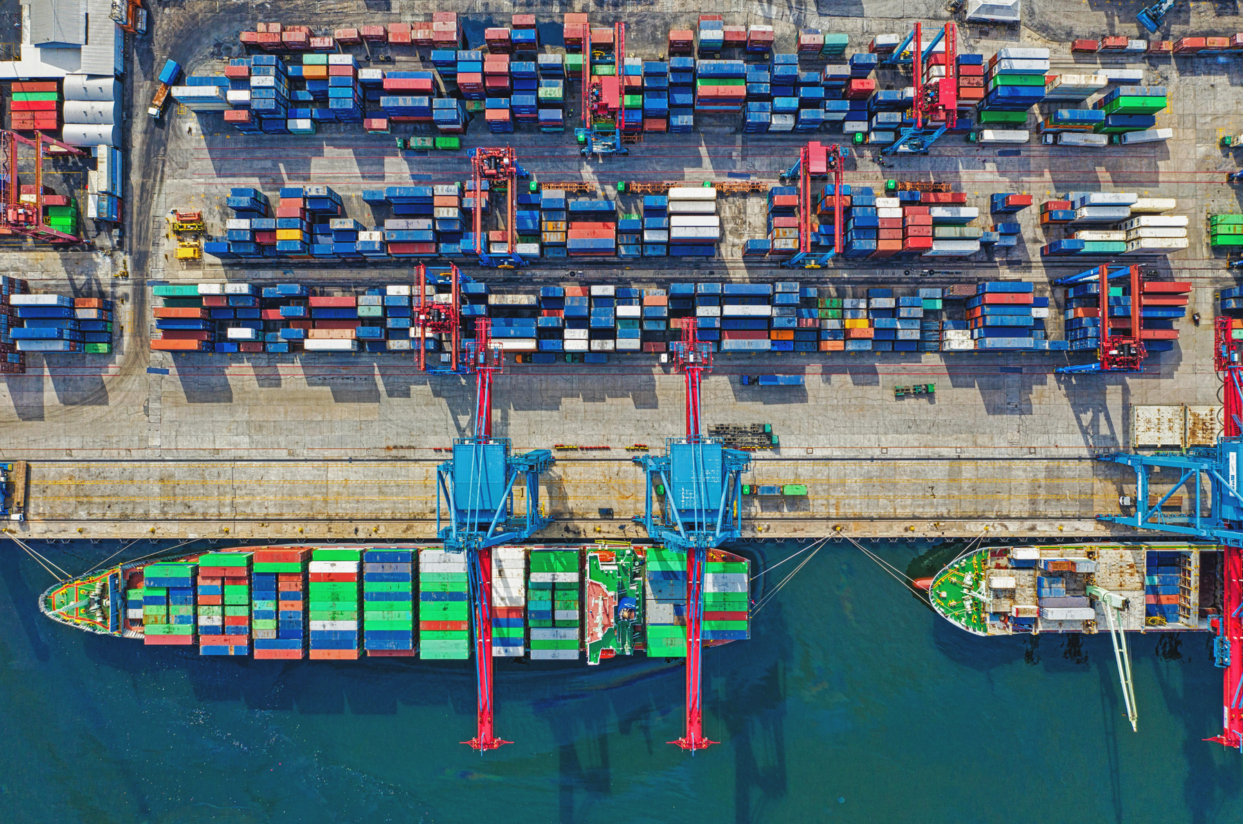 Porto com contêineres e navios de carga em operação de importação e exportação, representando logística e comércio exterior